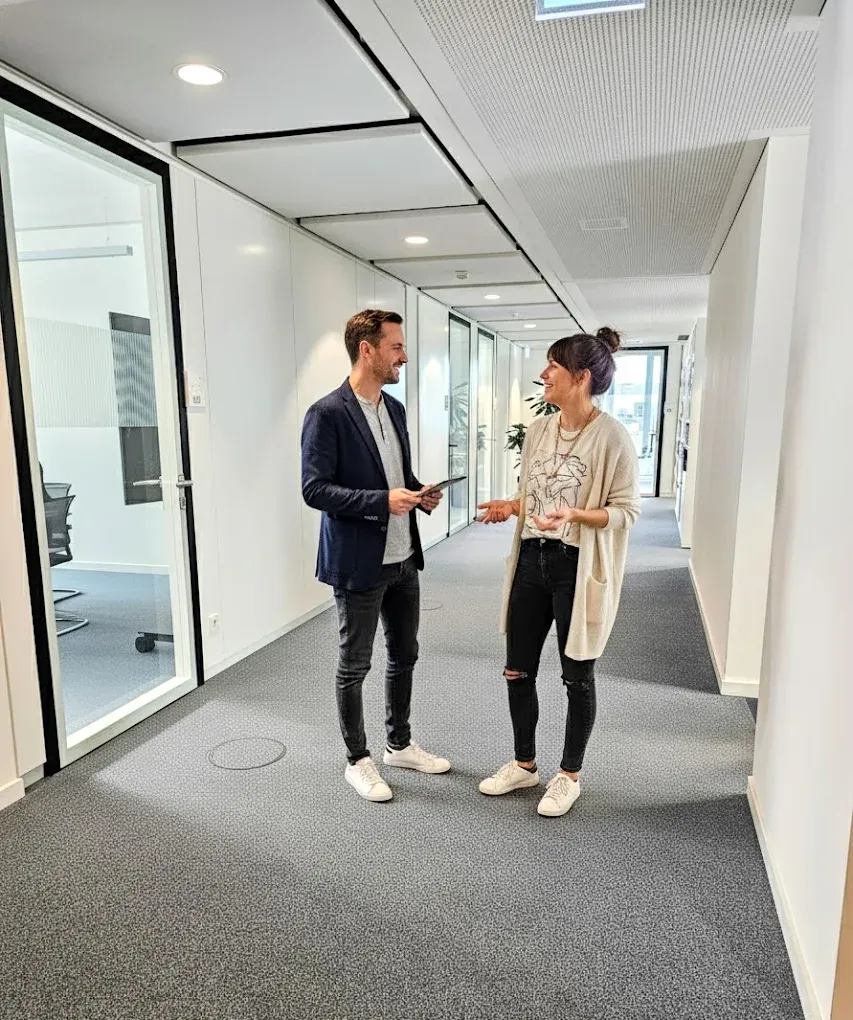 Two colleagues talking in the office corridor